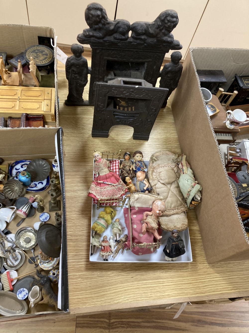 A collection of dolls and dolls house furniture displayed in room settings in a pine cupboard, width 84cm, depth 36cm, height 132cm